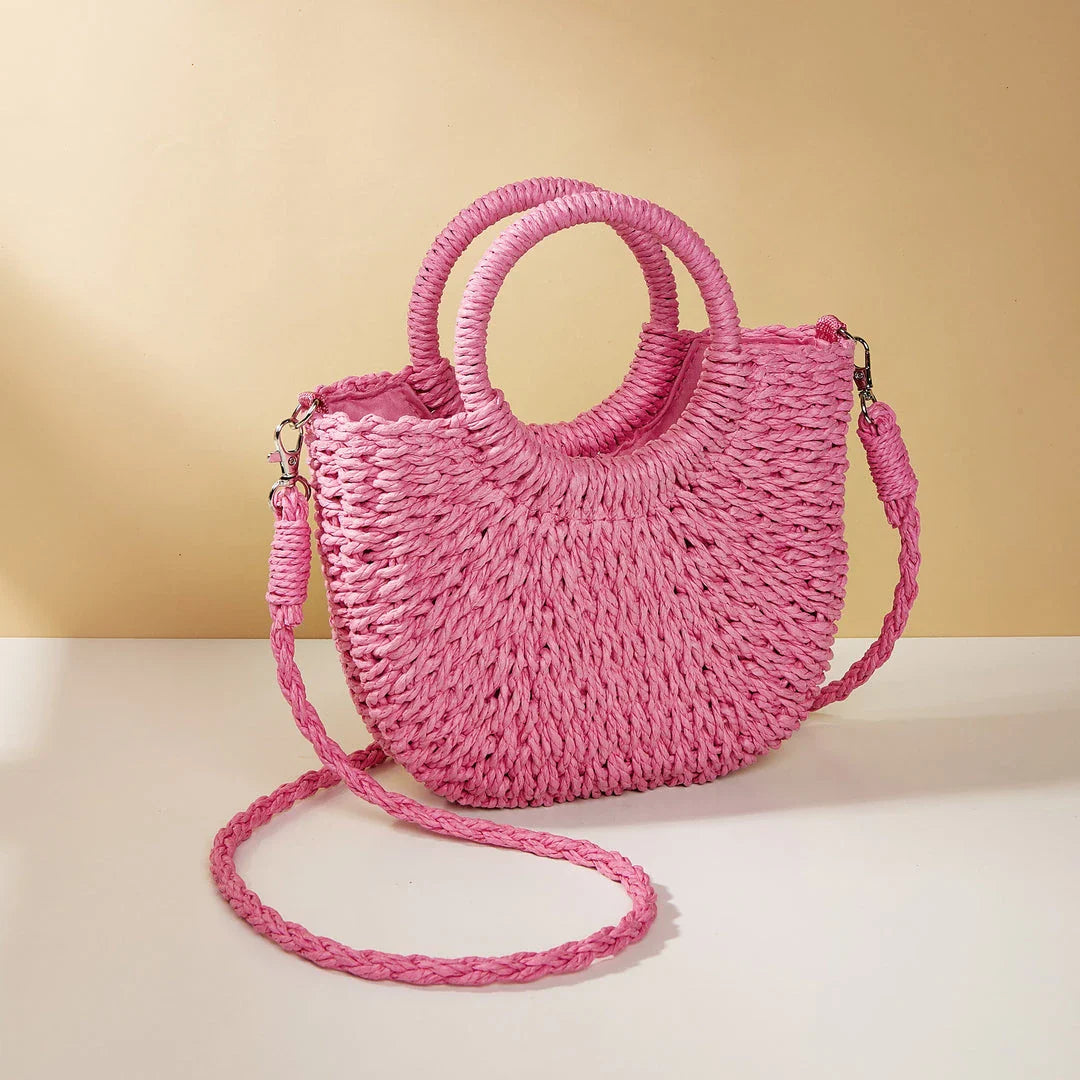 Stylish straw woven women's beach shoulder bag in a half-moon shape, featuring a cotton lining and string closure for a minimalist, bohemian-inspired look.