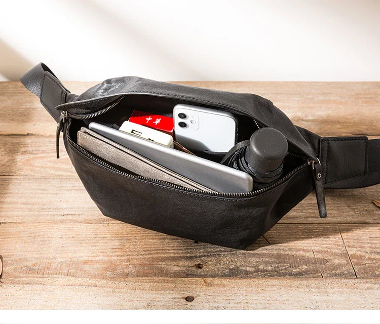 Premium cowhide messenger bag in black, featuring a spacious interior, adjustable shoulder strap, and sleek, minimalist design