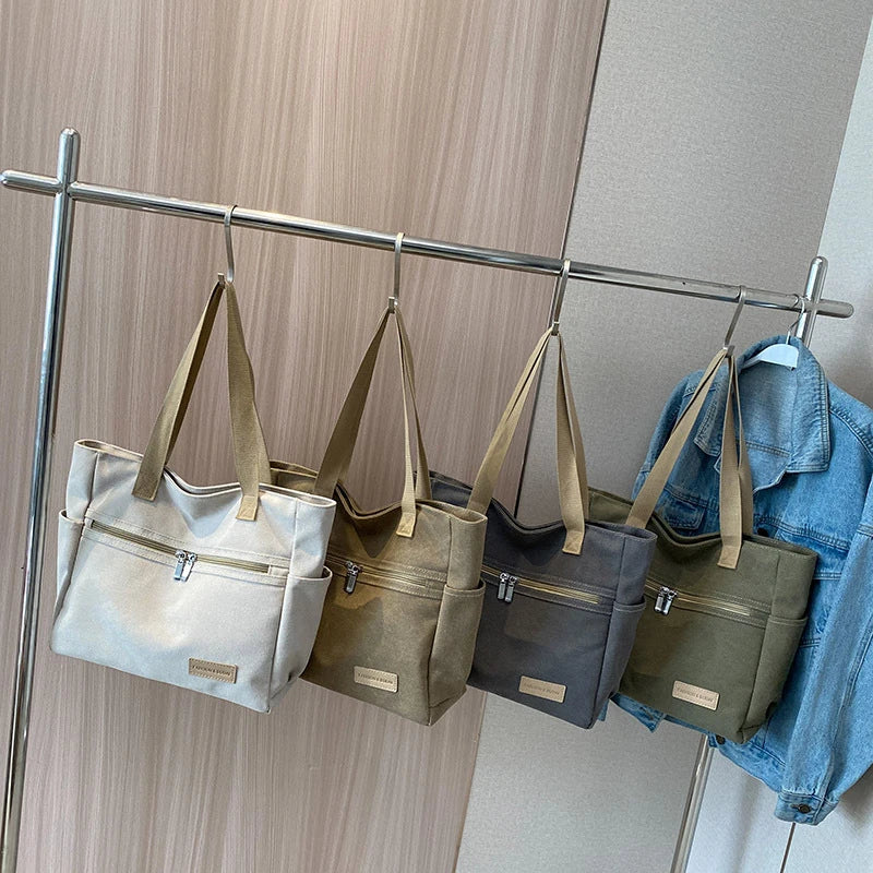 Premium canvas shoulder bag in grey, khaki, and green colours, featuring a stylish and functional design for everyday use.