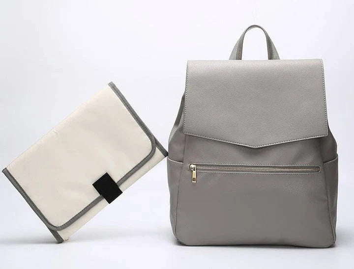 A stylish and practical PU leather mummy bag with a large capacity, multiple pockets, and included accessories like a changing pad and stroller hooks.