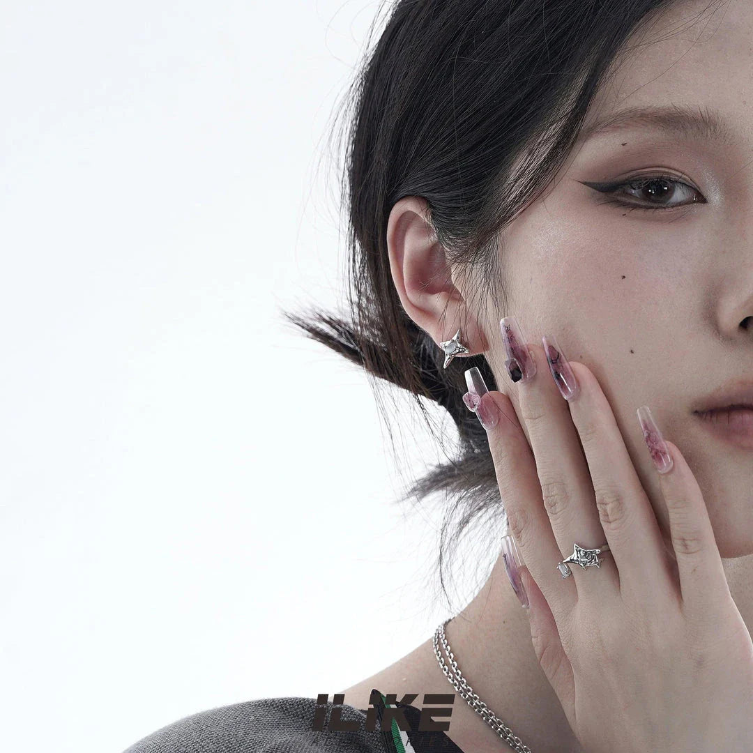 Pair of asymmetric silver stud earrings with intricate water drop and bell patterns, designed for modern British women
