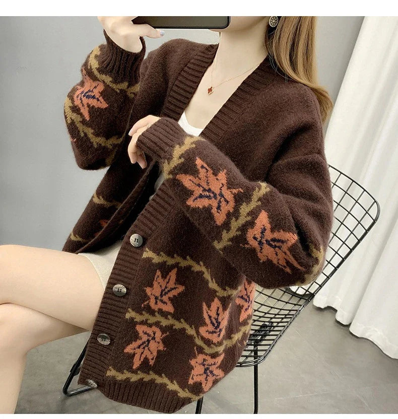 A cosy, loose-fitting women's cardigan sweater with a jacquard knitted maple leaf pattern in a range of neutral colours