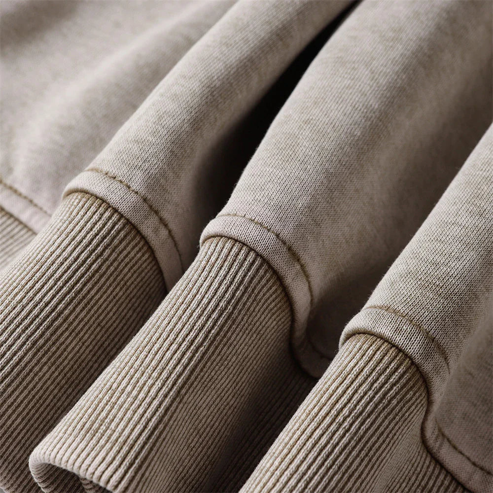 Embroidered cotton hoodie with a letter patch design, available in brown, grey, and black colours and sizes S to XL