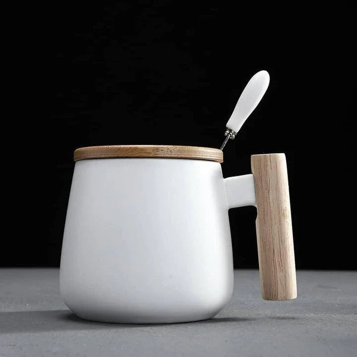 A stylish ceramic coffee mug with a colour block design and a coordinating wooden spoon