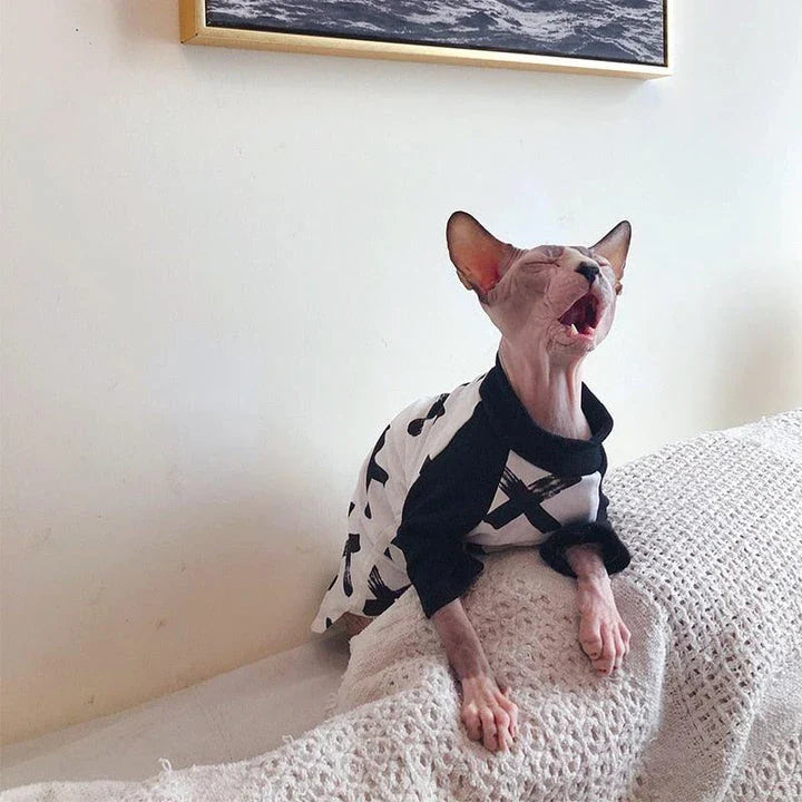 A stylish cotton sweater with a vibrant printed design and a coordinating necklace accessory, perfect for keeping your cat warm and fashionable.