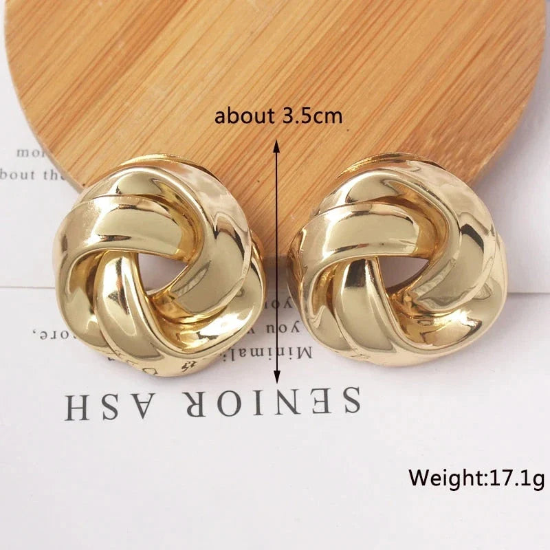 Pair of gold spiral drop earrings with an exaggerated, dramatic design for a bold, fashionable look