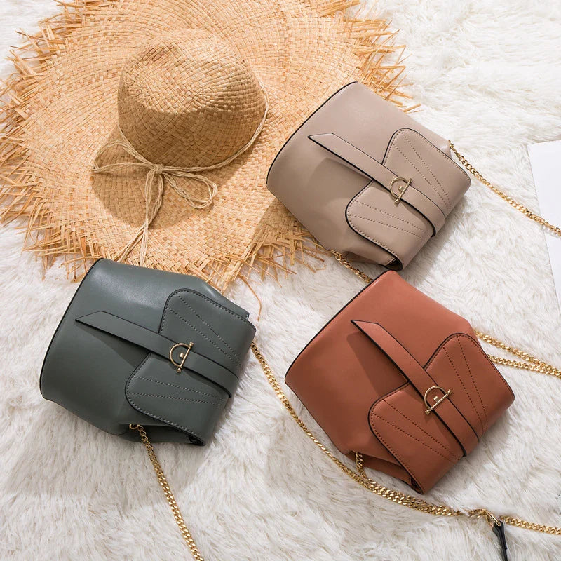 A large capacity chain bag with a classic bucket silhouette, crafted from premium leather-look material for sophisticated British style.