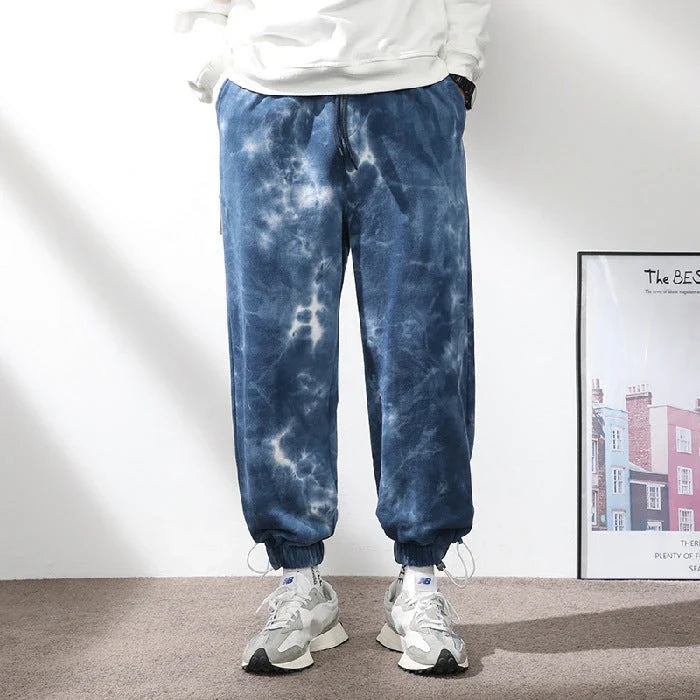 Stylish ankle-tied sweatpants in camouflage black, featuring an elasticated waistband, drawstring, and ankle ties for a relaxed yet refined look.