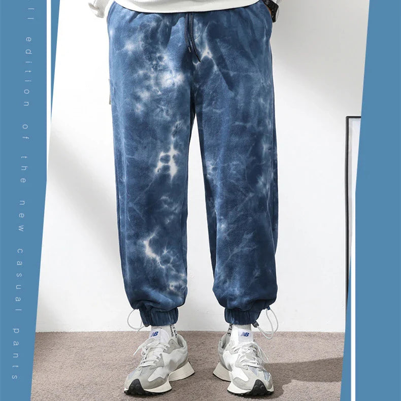 Stylish ankle-tied sweatpants in camouflage black, featuring an elasticated waistband, drawstring, and ankle ties for a relaxed yet refined look.