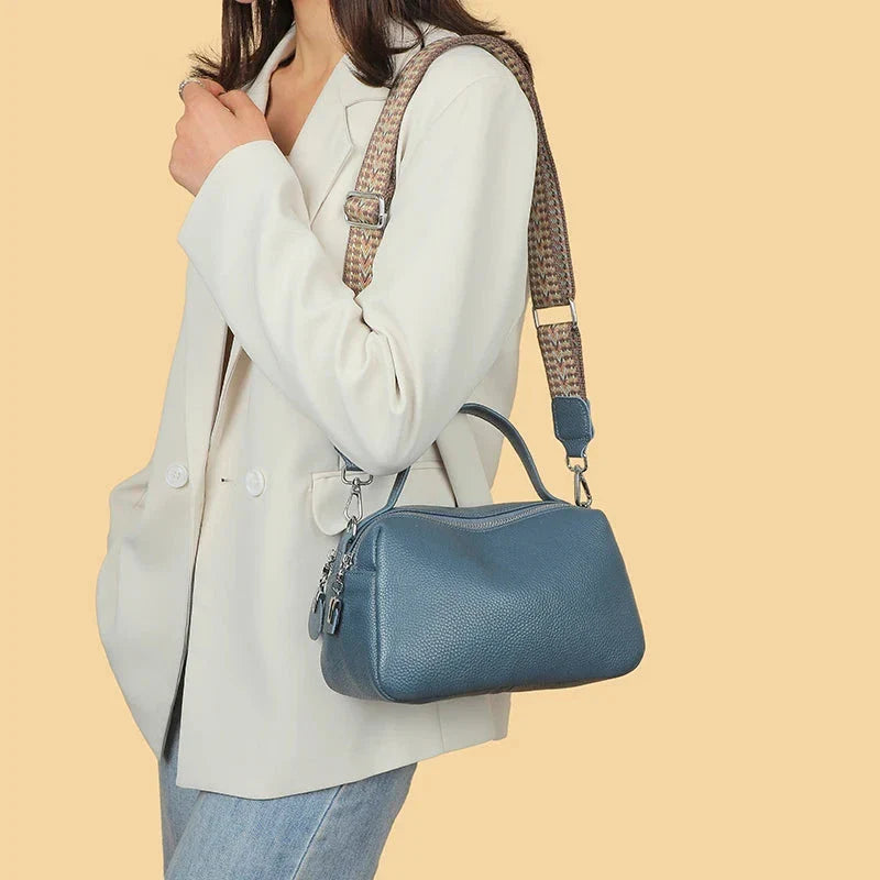 Luxurious genuine leather crossbody bag for women, featuring a soft polyester lining, dual phone pockets, and a compact, square design.