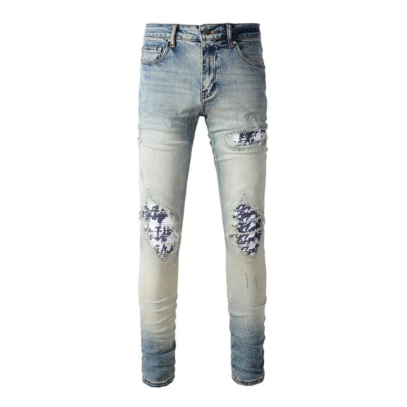 Stylish ripped denim jeans with a unique black and white patch design, perfect for British gentlemen
