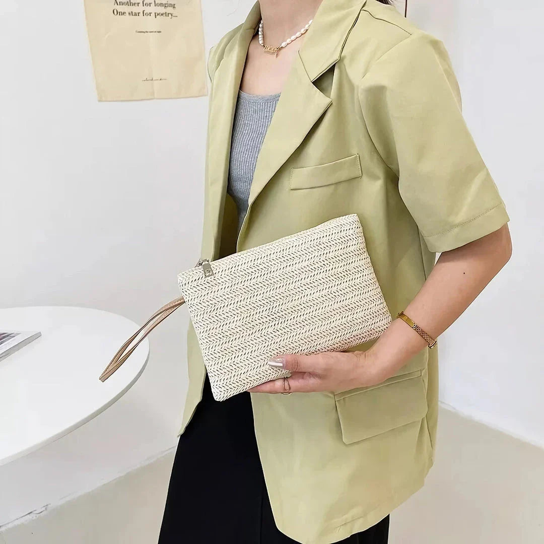 A natural straw-woven clutch with a zipper closure, perfect for summer outings in the UK.
