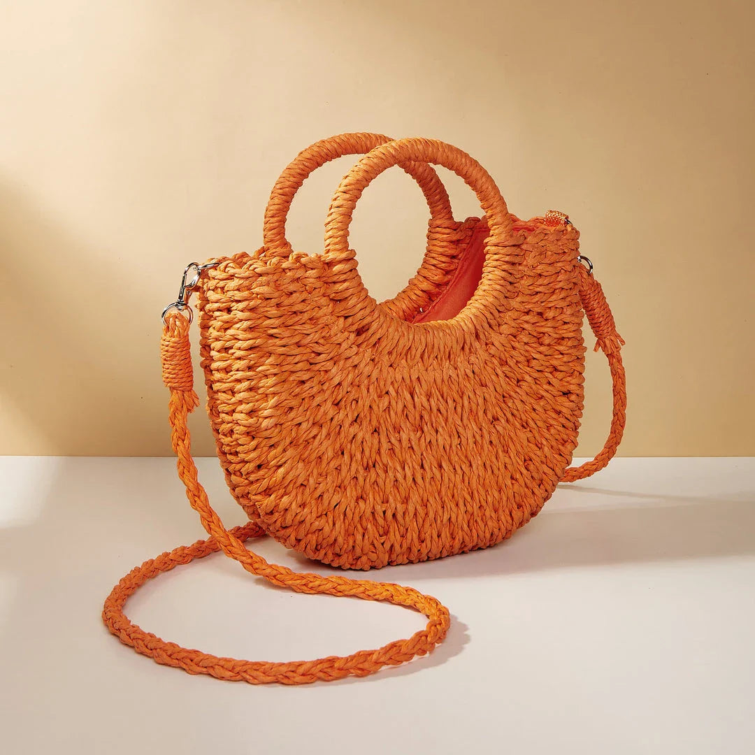 Stylish straw woven women's beach shoulder bag in a half-moon shape, featuring a cotton lining and string closure for a minimalist, bohemian-inspired look.
