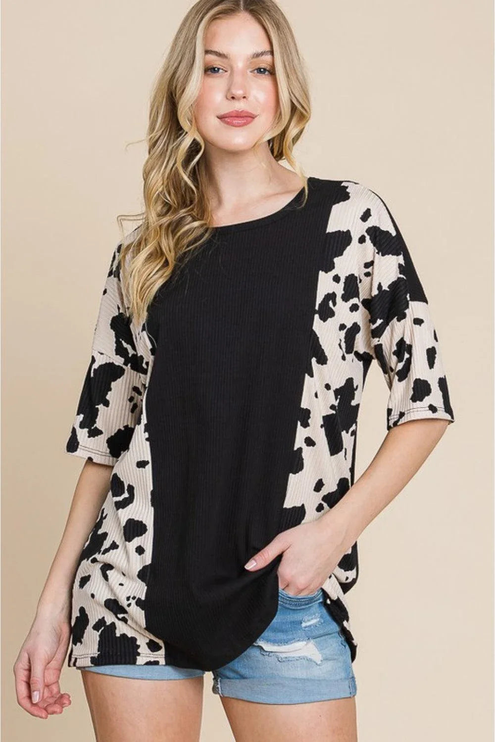 Stylish ribbed tee with playful cow print design, perfect for casual and smart-casual occasions.