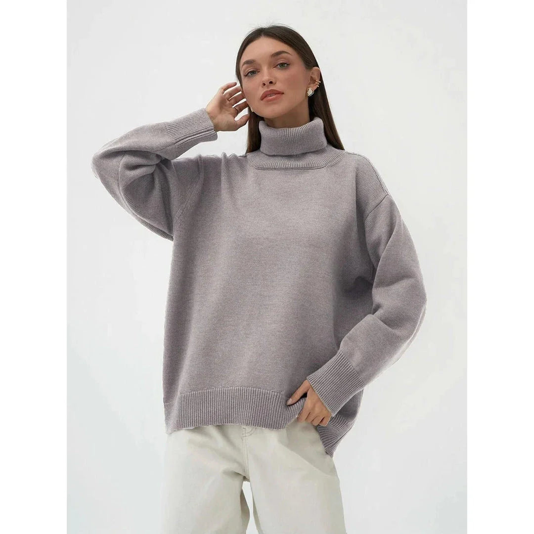 Cosy oversized knitted pullover in blue, featuring a classic turtleneck collar and drop-shoulder silhouette for maximum comfort and style.