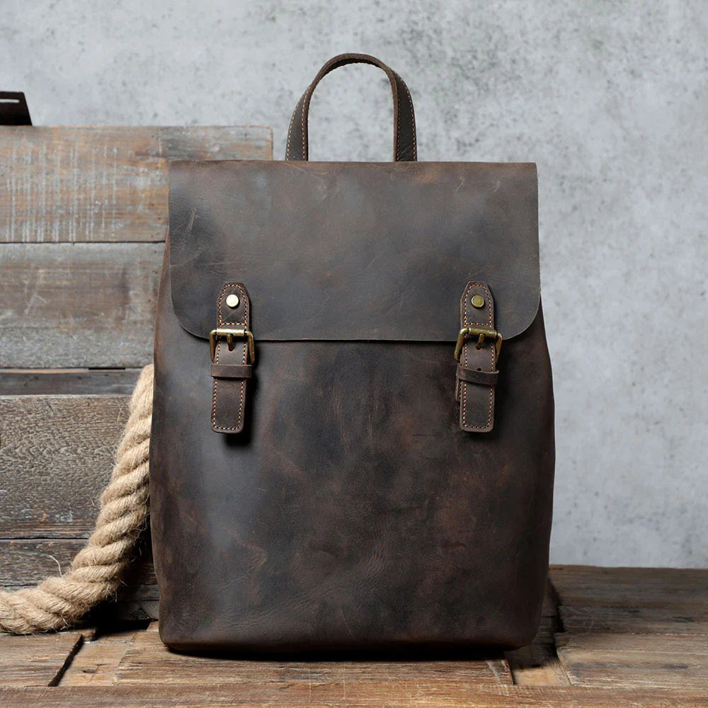 Premium vintage leather backpack with a classic design, featuring a spacious main compartment and adjustable padded shoulder straps for comfortable wear.