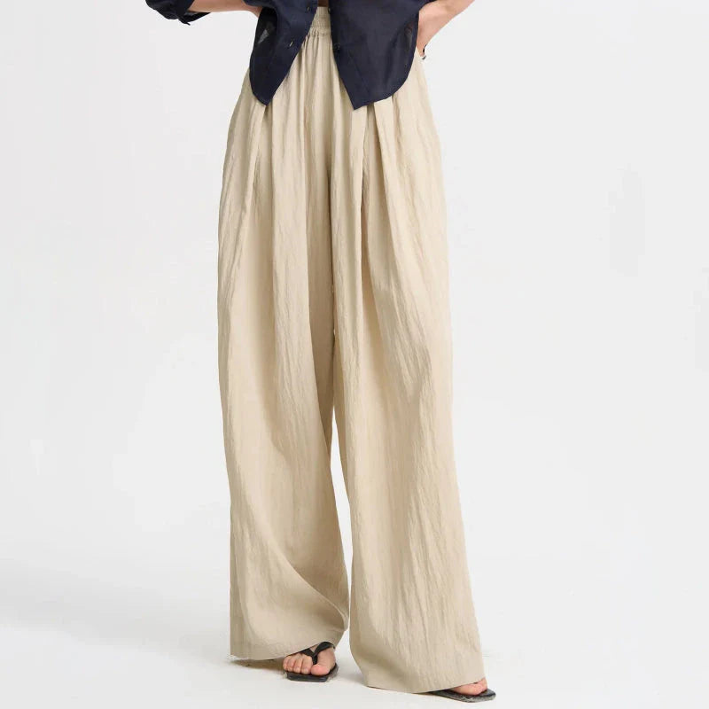 Pleated wide-leg high-waisted trousers in a herringbone plaid pattern, featuring a flattering silhouette and comfortable cotton-linen blend