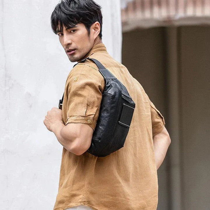 Premium cowhide messenger bag in black, featuring a spacious interior, adjustable shoulder strap, and sleek, minimalist design