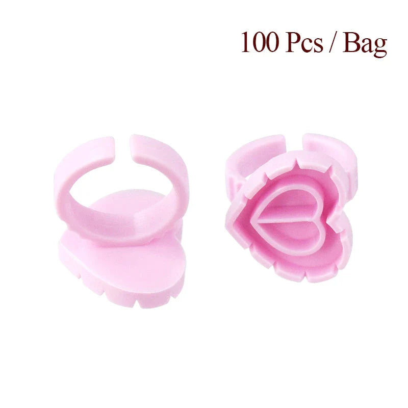 Heart-shaped disposable eyelash glue rings in blue, pink, and white colours