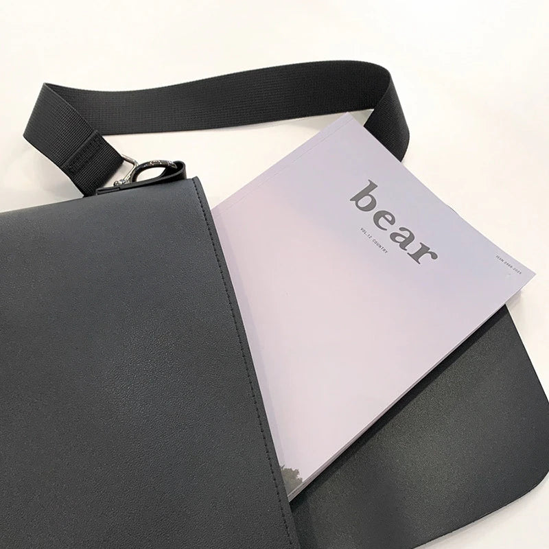 Black PU leather messenger bag with adjustable strap and zippered pockets, a stylish and practical accessory for British gentlemen