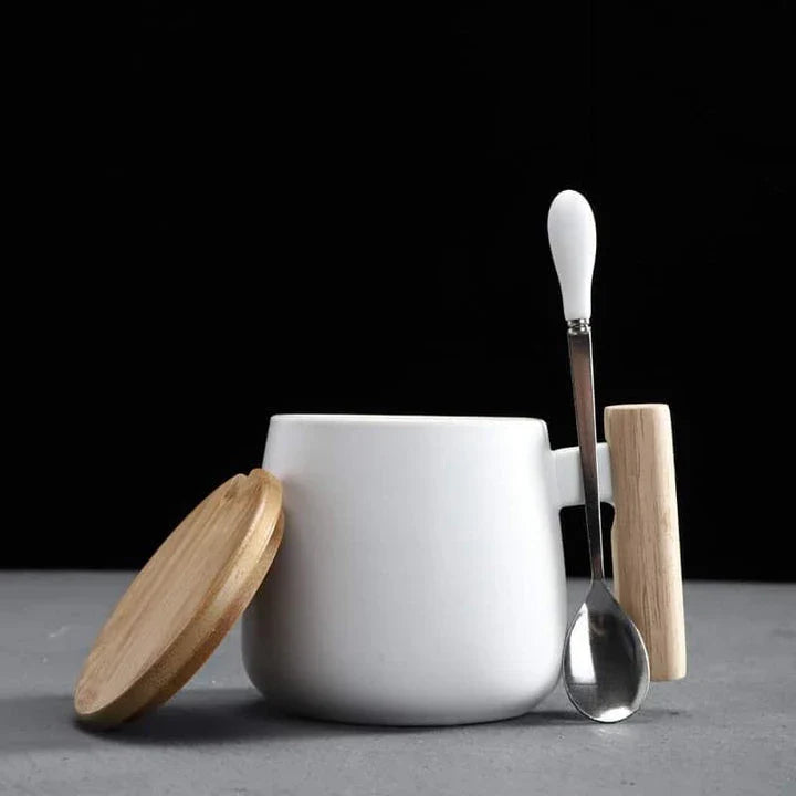 A stylish ceramic coffee mug with a colour block design and a coordinating wooden spoon