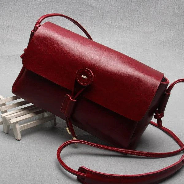 Premium leather crossbody bag in a sleek, horizontal square design with subtle car stitching details