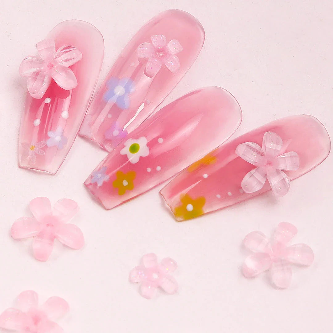 Elegant 3D flower nail charms in white and pink colours, featuring a transparent jelly finish and rhinestone accents for a stylish manicure