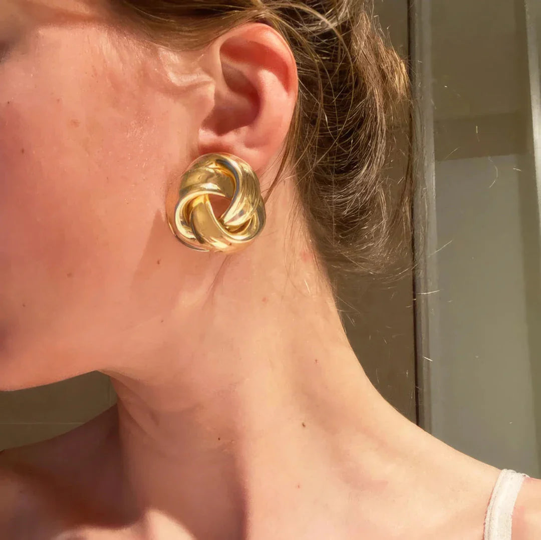 Pair of gold spiral drop earrings with an exaggerated, dramatic design for a bold, fashionable look