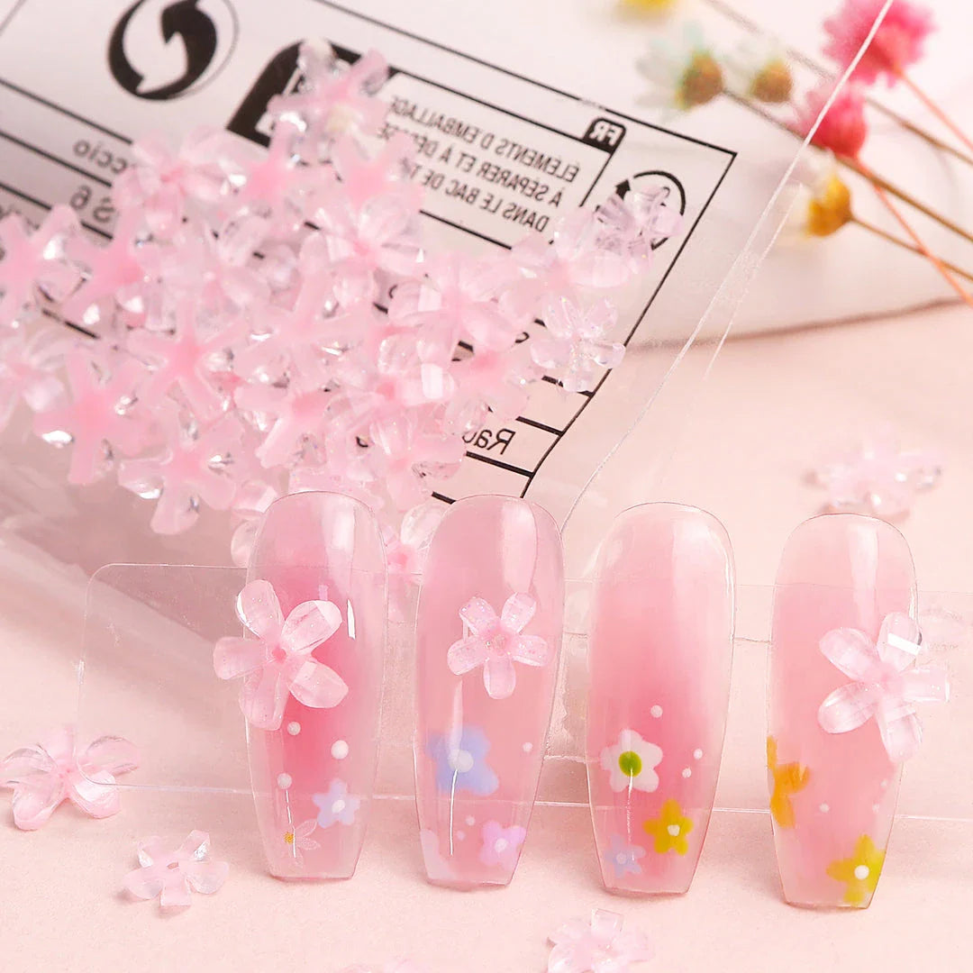 Elegant 3D flower nail charms in white and pink colours, featuring a transparent jelly finish and rhinestone accents for a stylish manicure