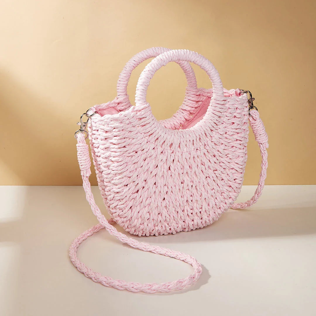 Stylish straw woven women's beach shoulder bag in a half-moon shape, featuring a cotton lining and string closure for a minimalist, bohemian-inspired look.