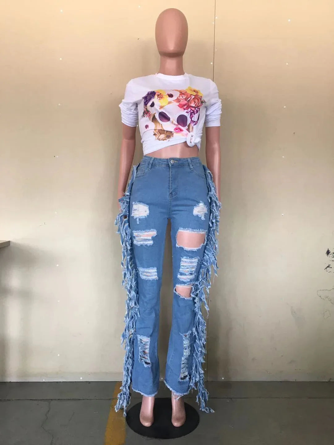 Stylishly distressed tassel jeans with light blue wash and straight-leg silhouette