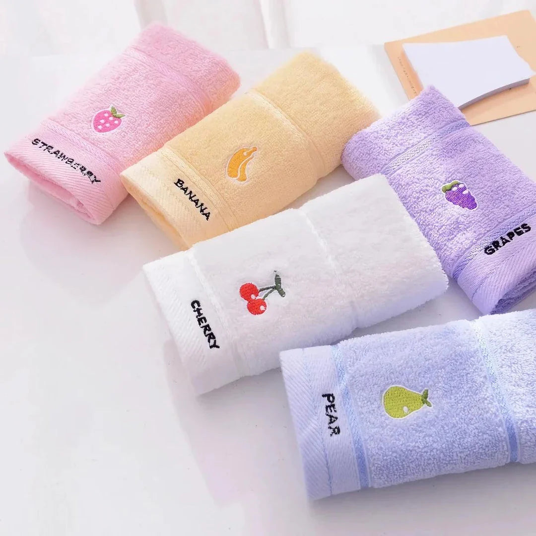 Soft cotton baby bath towel with adorable cartoon fruit face designs in pink