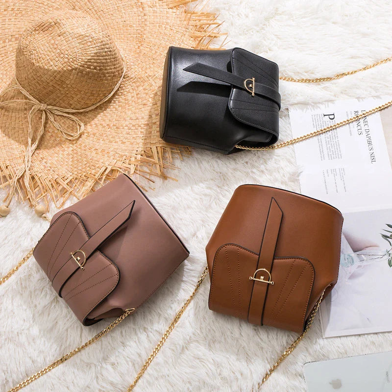 A large capacity chain bag with a classic bucket silhouette, crafted from premium leather-look material for sophisticated British style.