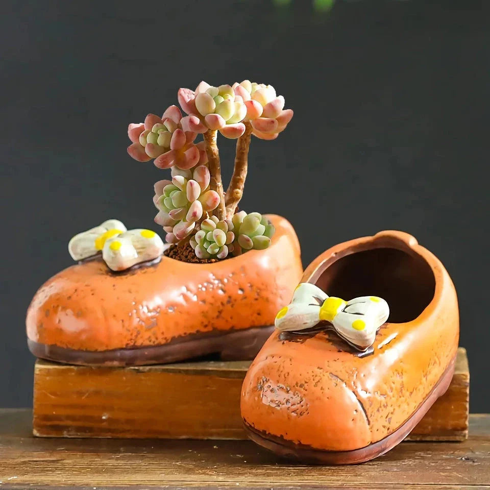 Charming ceramic boot-shaped vase with a glazed finish, perfect for displaying succulents and flowers in your home or garden