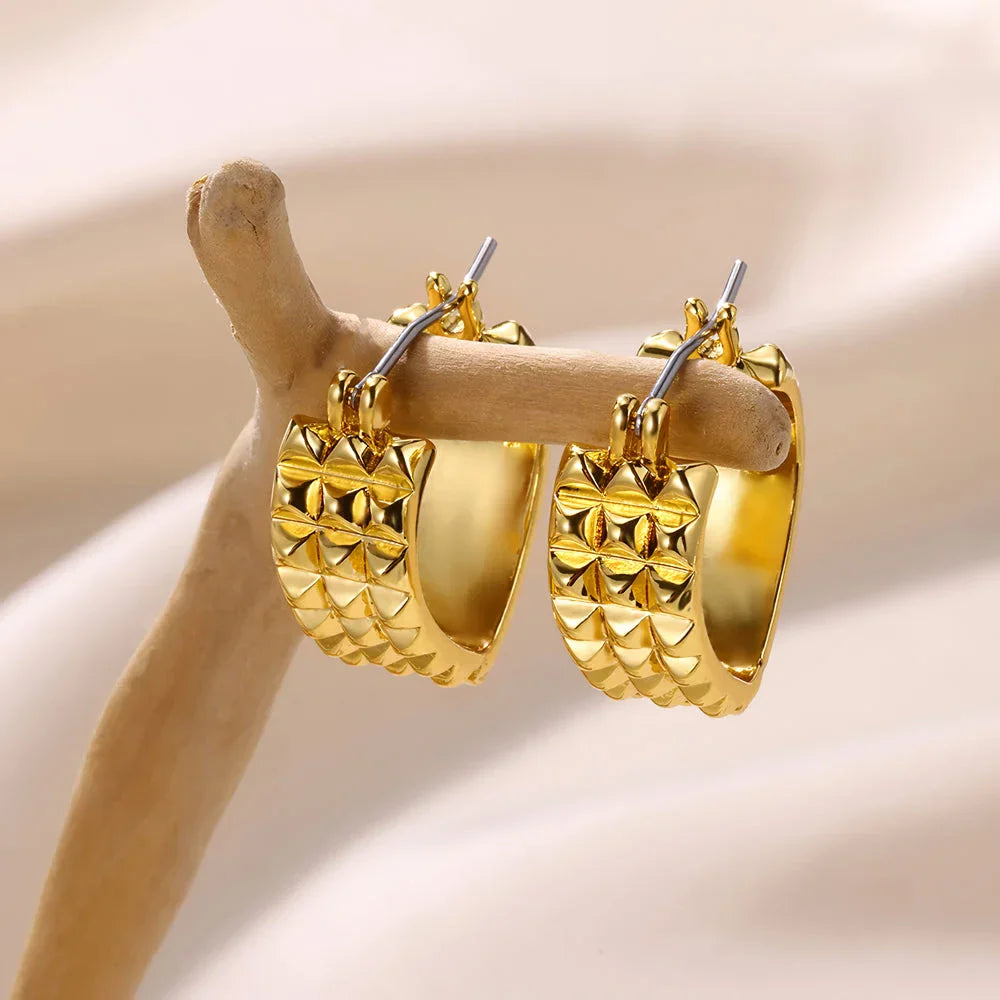 A pair of gold-toned stainless steel hoop earrings, showcasing a classic and sophisticated design