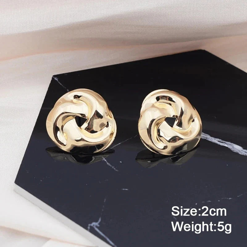 Pair of gold spiral drop earrings with an exaggerated, dramatic design for a bold, fashionable look