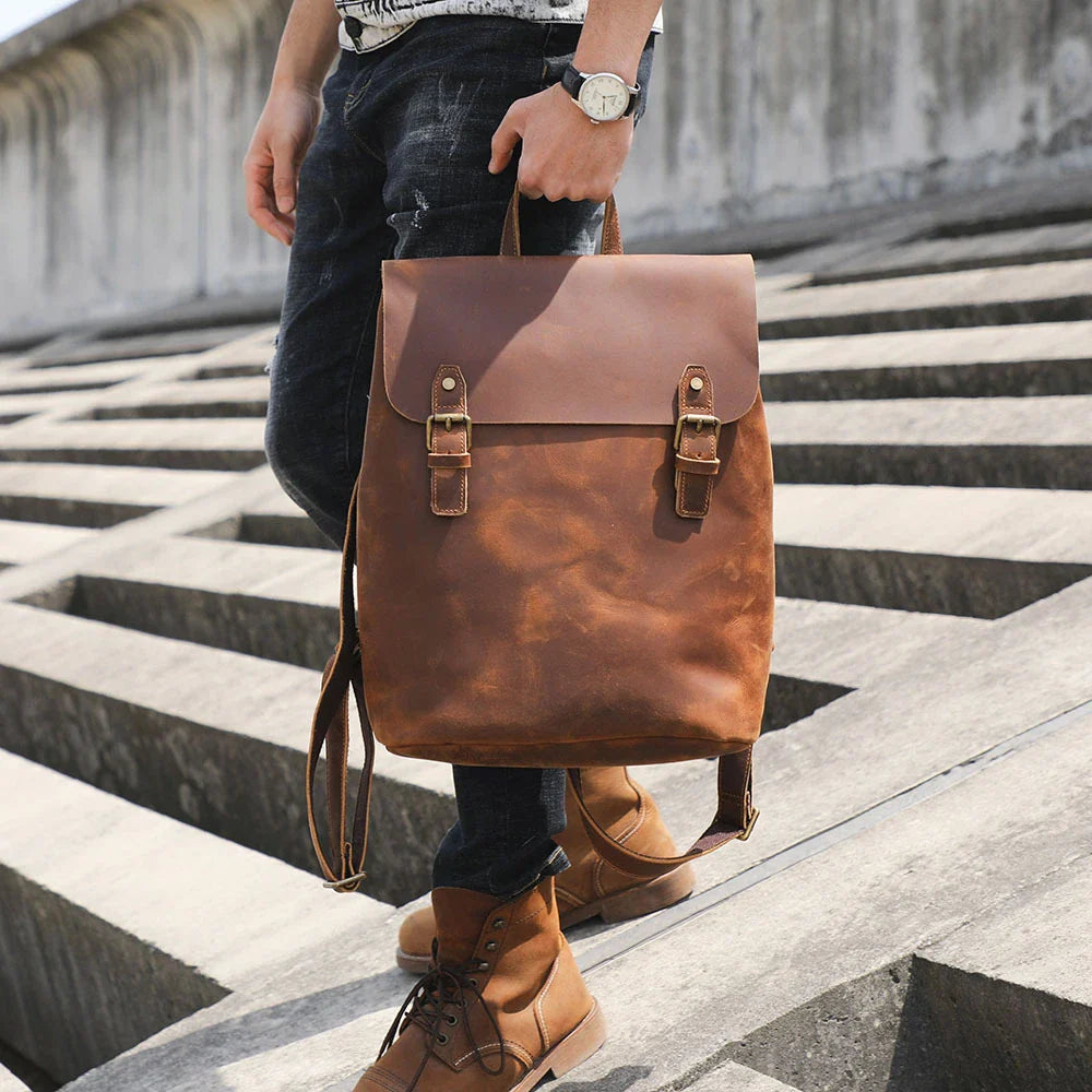 Premium vintage leather backpack with a classic design, featuring a spacious main compartment and adjustable padded shoulder straps for comfortable wear.