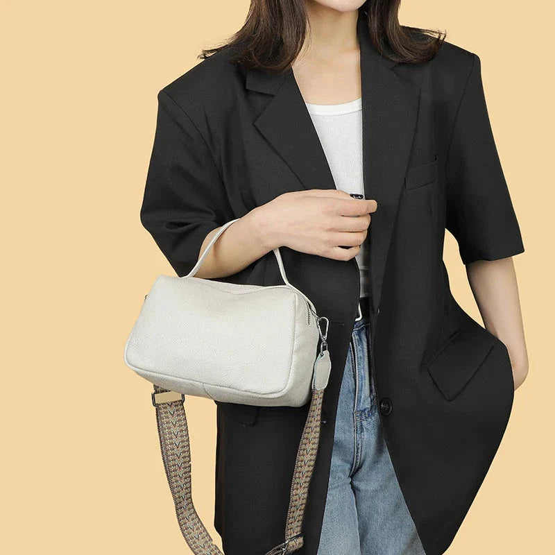 Luxurious genuine leather crossbody bag for women, featuring a soft polyester lining, dual phone pockets, and a compact, square design.