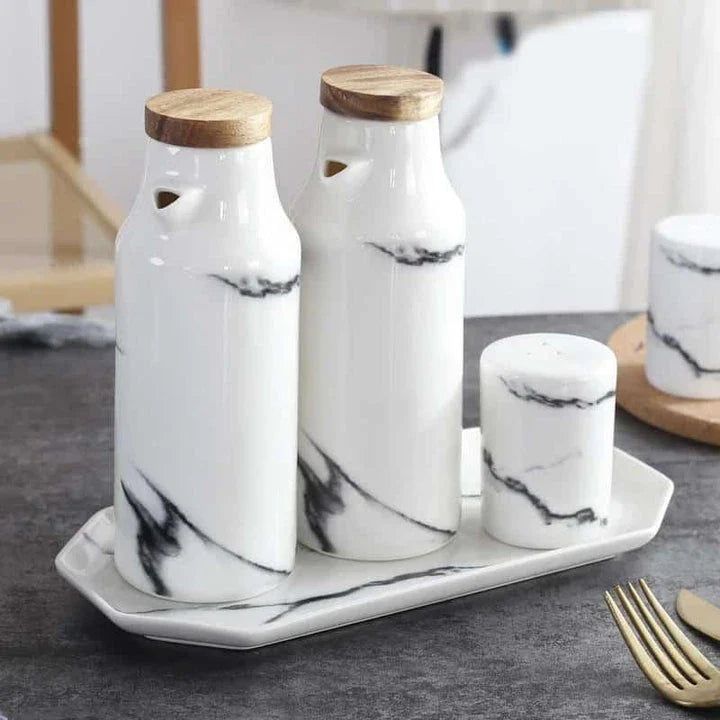 Ceramic salt and pepper shaker set with oil bottle in light grey porcelain finish, featuring minimalist design and easy-grip handles