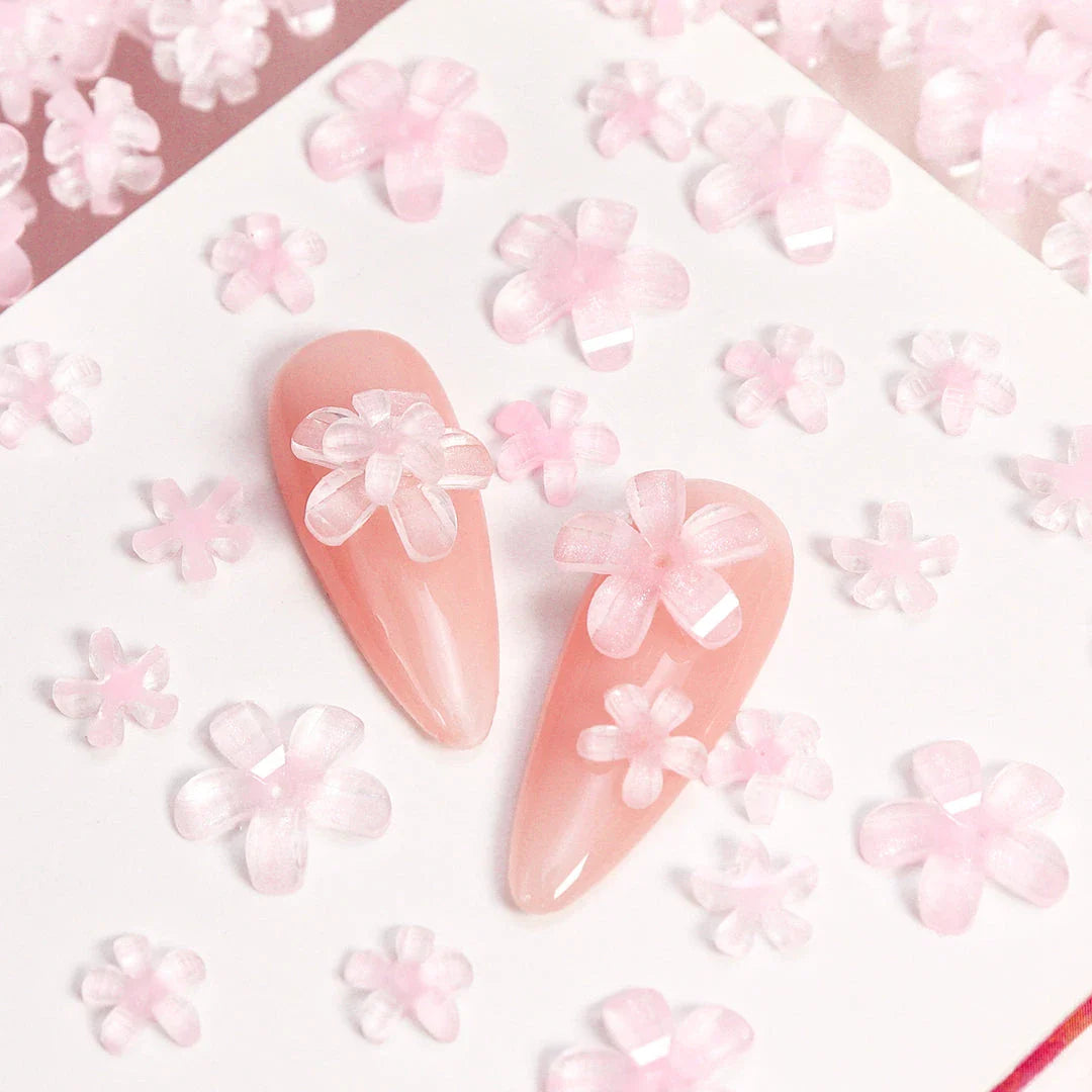 Elegant 3D flower nail charms in white and pink colours, featuring a transparent jelly finish and rhinestone accents for a stylish manicure