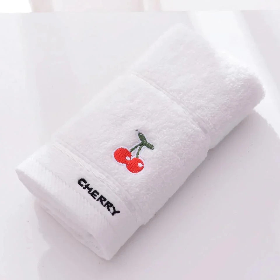 Soft cotton baby bath towel with adorable cartoon fruit face designs in pink