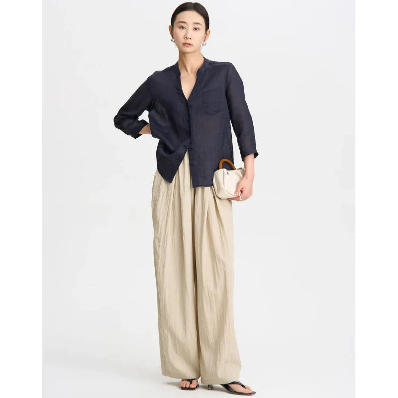 Pleated wide-leg high-waisted trousers in a herringbone plaid pattern, featuring a flattering silhouette and comfortable cotton-linen blend