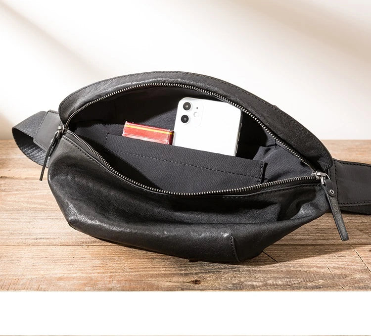 Premium cowhide messenger bag in black, featuring a spacious interior, adjustable shoulder strap, and sleek, minimalist design