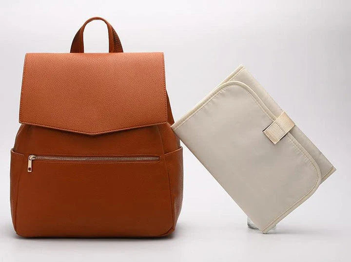 A stylish and practical PU leather mummy bag with a large capacity, multiple pockets, and included accessories like a changing pad and stroller hooks.