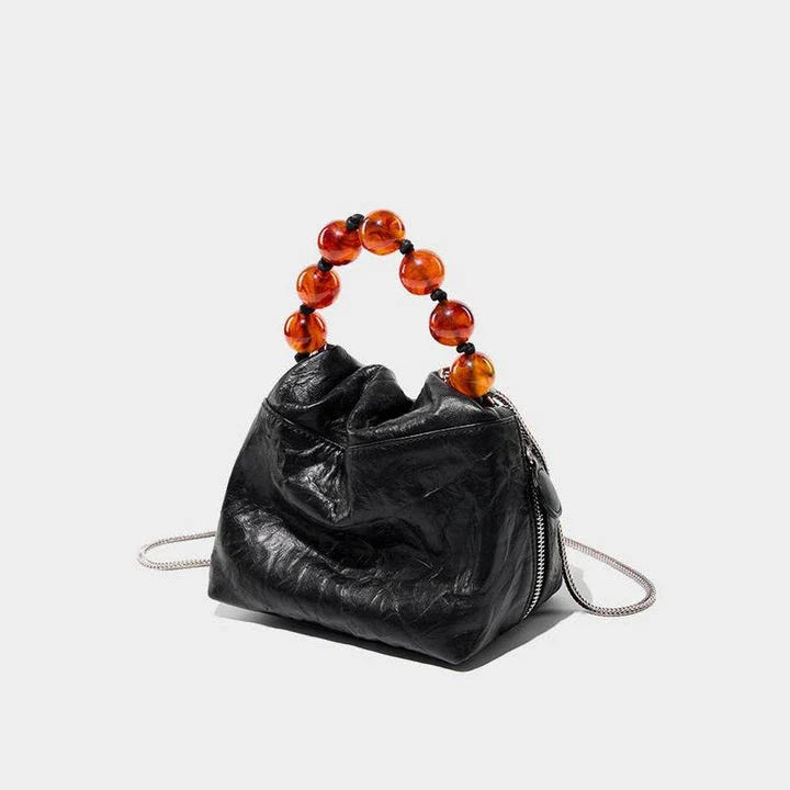 Premium leather crossbody bag with intricate beadwork, featuring a classic saddle shape and adjustable shoulder straps for versatile and secure everyday use.