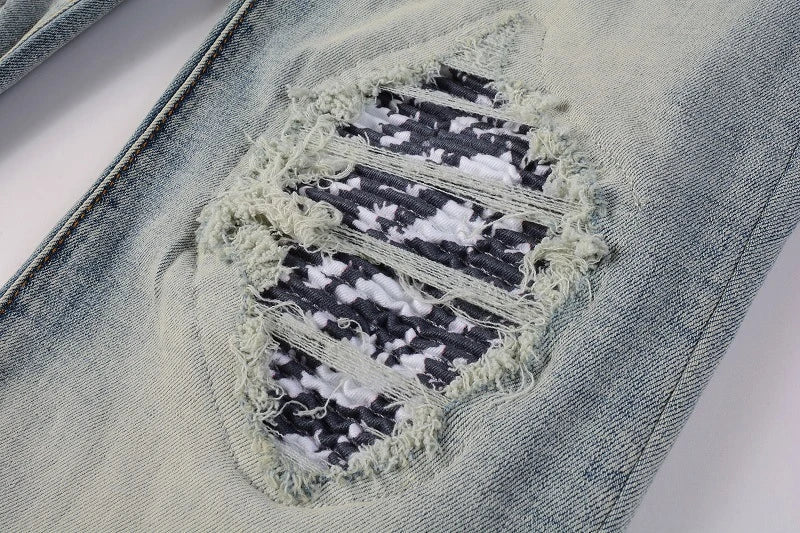 Stylish ripped denim jeans with a unique black and white patch design, perfect for British gentlemen