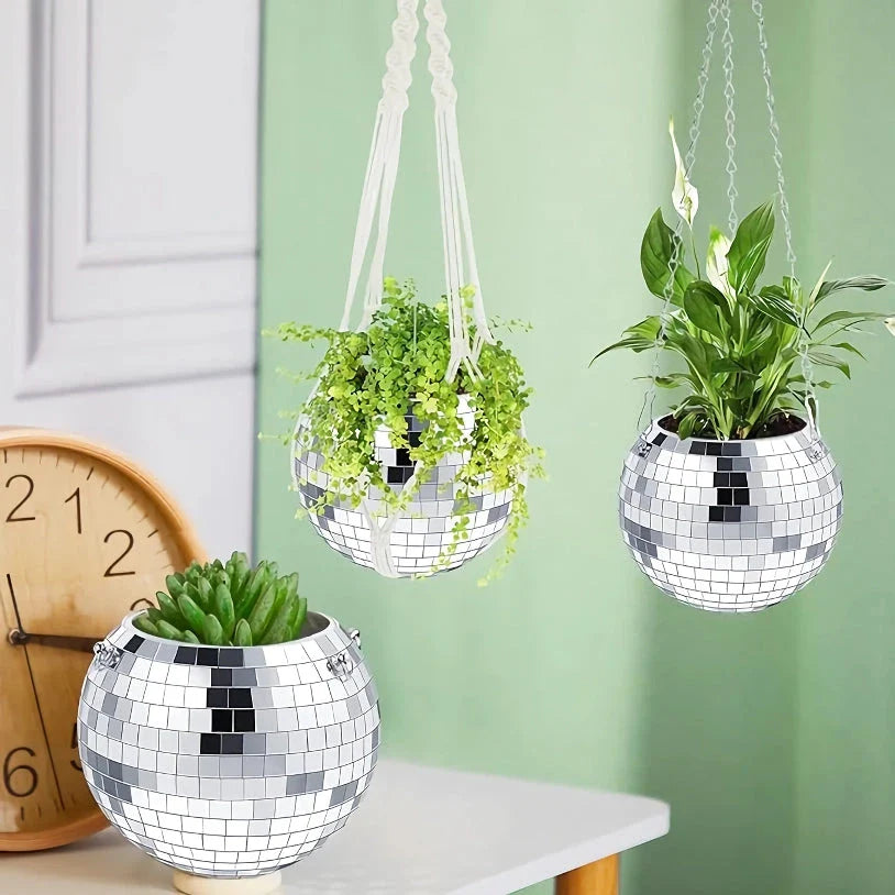 A sparkling silver disco ball hanging planter with reflective glass mirrors, adding a modern and stylish touch to any indoor or outdoor space.