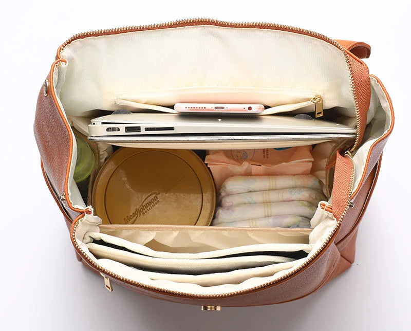 A stylish and practical PU leather mummy bag with a large capacity, multiple pockets, and included accessories like a changing pad and stroller hooks.