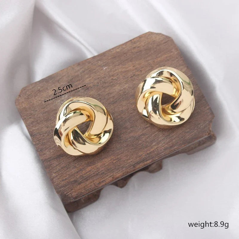 Pair of gold spiral drop earrings with an exaggerated, dramatic design for a bold, fashionable look