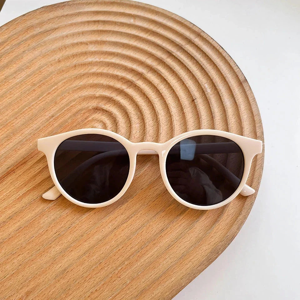 A pair of stylish, retro-inspired round sunglasses with a white frame, providing UV protection and a chic, contemporary look.